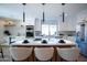 Bright kitchen featuring a quartz island with barstool seating, stainless steel appliances, and modern pendant lighting at 15440 N 54Th St, Scottsdale, AZ 85254