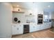 Bright kitchen with white cabinets, floating shelves, and a beverage cooler at 15440 N 54Th St, Scottsdale, AZ 85254