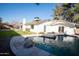 Inviting backyard pool with stone surround and a white home exterior at 15440 N 54Th St, Scottsdale, AZ 85254