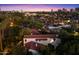 Aerial view of a lovely home with a red tile roof with the city skyline in the background at twilight at 1614 Palmcroft Sw Dr, Phoenix, AZ 85007