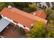 Aerial view of a home showcasing a red tile roof, a backyard pool, and lush landscaping, surrounded by greenery at 1614 Palmcroft Sw Dr, Phoenix, AZ 85007