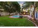 Lush backyard featuring a pool, outdoor dining, a well-manicured lawn and verdant landscaping at 1614 Palmcroft Sw Dr, Phoenix, AZ 85007