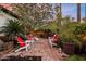 Inviting backyard patio featuring multiple seating areas, lush landscaping, and ambient string lighting at 1614 Palmcroft Sw Dr, Phoenix, AZ 85007