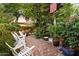 Backyard patio featuring brick paving, ample seating, lush landscaping, and string lights, perfect for outdoor relaxation at 1614 Palmcroft Sw Dr, Phoenix, AZ 85007