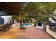 Backyard view of the patio, pool, outdoor kitchen, and the dining area, with lush landscaping at 1614 Palmcroft Sw Dr, Phoenix, AZ 85007