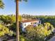 Picturesque home exterior featuring a tile roof, lush greenery, and a backdrop of the city skyline at 1614 Palmcroft Sw Dr, Phoenix, AZ 85007