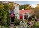 Charming home featuring a red tile roof, lush landscaping, and an inviting red front door at 1614 Palmcroft Sw Dr, Phoenix, AZ 85007