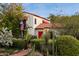 Gorgeous home with lush landscaping, a red tile roof and a charming red door exuding curb appeal at 1614 Palmcroft Sw Dr, Phoenix, AZ 85007