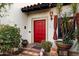 Charming home featuring a red door framed with decorative tiles and manicured landscaping at 1614 Palmcroft Sw Dr, Phoenix, AZ 85007