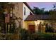 Charming home exterior with red-tile roof, wrought iron balcony with US flag and a well manicured and enclosed front yard at 1614 Palmcroft Sw Dr, Phoenix, AZ 85007