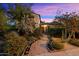 Inviting home exterior with lush landscaping, a brick path, and mature desert plants under a vibrant sky at 1614 Palmcroft Sw Dr, Phoenix, AZ 85007