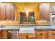 Close-up of a bright kitchen with wood cabinets and a view of trees through the window at 1614 Palmcroft Sw Dr, Phoenix, AZ 85007