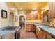 Well-lit kitchen featuring tile floors, wood cabinets, and open access to other rooms at 1614 Palmcroft Sw Dr, Phoenix, AZ 85007