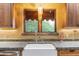 Bright kitchen featuring a large farmhouse sink, green tile countertop, and a view of green foliage through the window at 1614 Palmcroft Sw Dr, Phoenix, AZ 85007