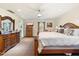 A spacious main bedroom featuring carpet, wooden accents, and a large dresser with ornate mirror at 1614 Palmcroft Sw Dr, Phoenix, AZ 85007