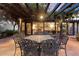 Outdoor dining area with seating for eight, covered by a pergola and overlooking the living room at 1614 Palmcroft Sw Dr, Phoenix, AZ 85007