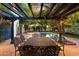 Backyard patio with a dining set under a pergola, looking out to the pool and manicured yard at 1614 Palmcroft Sw Dr, Phoenix, AZ 85007