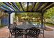 Under a pergola, enjoy outdoor dining with a wrought iron table set beside the refreshing swimming pool at 1614 Palmcroft Sw Dr, Phoenix, AZ 85007