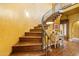 Elegant staircase featuring curved wrought iron railing and warm wood treads to the upper level at 1614 Palmcroft Sw Dr, Phoenix, AZ 85007