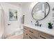 Modern bathroom showcasing wood vanity, round mirror, stylish fixtures, and a tub with shower at 16560 N Slate Ln, Maricopa, AZ 85139