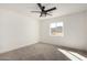 Bright bedroom features soft carpet, a window with views, and a modern ceiling fan at 16560 N Slate Ln, Maricopa, AZ 85139