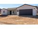 Classic single-story home featuring white stucco siding, dark trim and a gray garage door at 16560 N Slate Ln, Maricopa, AZ 85139