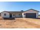 Well-built single-story home featuring stucco siding, dark trim and a gray garage door at 16560 N Slate Ln, Maricopa, AZ 85139