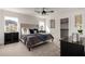 Comfortable main bedroom features a ceiling fan, plush bedding, and bright natural light at 16560 N Slate Ln, Maricopa, AZ 85139