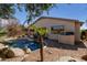 Lush backyard showcasing a sparkling pool, desert landscaping, and a built-in barbecue area for outdoor entertaining at 17560 W Desert View Ln, Goodyear, AZ 85338