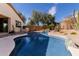 Gorgeous pool with rock waterfall feature surrounded by lush desert landscaping, creating a private backyard retreat at 17560 W Desert View Ln, Goodyear, AZ 85338