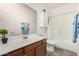 Well-lit bathroom with a single sink vanity, framed mirror, shower, and toilet at 17560 W Desert View Ln, Goodyear, AZ 85338