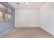 Bedroom featuring a blue accent wall, large window and neutral carpet at 17560 W Desert View Ln, Goodyear, AZ 85338