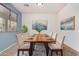 Elegant dining room with a wood table set for eight, modern lighting, and neutral decor at 17560 W Desert View Ln, Goodyear, AZ 85338