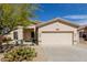 Tan single-story home with desert landscaping, a two-car garage, and blue skies at 17560 W Desert View Ln, Goodyear, AZ 85338