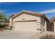 Beige single-story home with desert landscaping and two-car garage at 17560 W Desert View Ln, Goodyear, AZ 85338