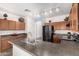 Functional kitchen with wooden cabinetry, black appliances, and a large island at 17560 W Desert View Ln, Goodyear, AZ 85338