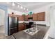 Kitchen with stainless steel sink, black appliances, oak cabinets, and track lighting at 17560 W Desert View Ln, Goodyear, AZ 85338