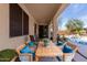 Covered patio with dining set, cozy seating, and a view of the landscaped yard at 17560 W Desert View Ln, Goodyear, AZ 85338