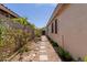 Charming side yard featuring a stone pathway lined with lush greenery, adding a touch of natural beauty at 17560 W Desert View Ln, Goodyear, AZ 85338