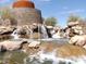 Unique water feature with stone tower and cascading waterfalls, adding charm and serenity to the community at 17560 W Desert View Ln, Goodyear, AZ 85338