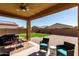 This covered patio features neutral tones, outdoor seating, and a ceiling fan at 17577 W Desert Bloom St, Goodyear, AZ 85338