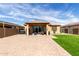 A spacious brick patio extends from the home to the artificial turf backyard at 17577 W Desert Bloom St, Goodyear, AZ 85338