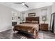 Bedroom featuring a large bed, ceiling fan, and ensuite bathroom at 17577 W Desert Bloom St, Goodyear, AZ 85338