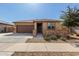 Charming single-story home with a well-manicured front yard, stone accents, and a two-car garage at 17577 W Desert Bloom St, Goodyear, AZ 85338