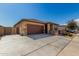 Beautiful home with a two-car garage, a stone accent wall, and desert landscaping in the front yard at 17577 W Desert Bloom St, Goodyear, AZ 85338