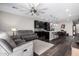 Open-concept living space with dark wood floors and contemporary furnishings, seamlessly connecting to the kitchen at 17577 W Desert Bloom St, Goodyear, AZ 85338