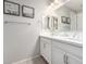 Bright bathroom featuring double sinks, framed mirrors, and a vanity area at 17588 W Maricopa St, Goodyear, AZ 85338