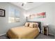 Cozy bedroom with warm yellow colored bedding, neutral walls, and natural light at 17588 W Maricopa St, Goodyear, AZ 85338