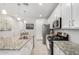 Well-lit kitchen with granite countertops, stainless steel appliances, and white cabinets at 17588 W Maricopa St, Goodyear, AZ 85338