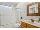 Clean bathroom featuring a shower-tub combo, white tile, and vanity with framed mirror at 19595 N 107Th Dr, Sun City, AZ 85373